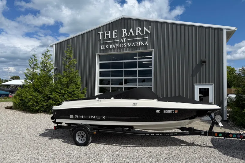 The Image of 2012 Bayliner 175 boat at Elk Rapids Marina, parked outside "The Barn" building. - 1