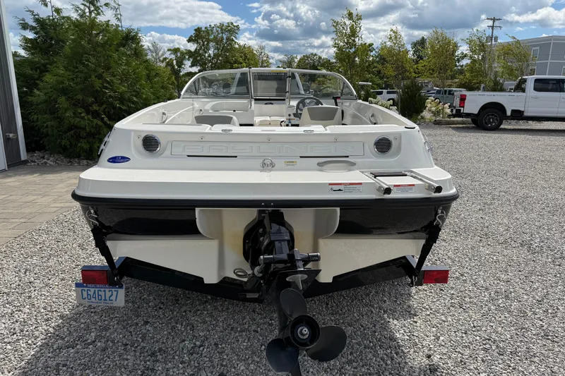 Slide: The Image of 2012 Bayliner 175 boat, rear view, parked on gravel, showcasing outboard motor. - 4