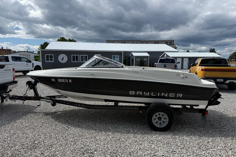 Slide: The Image of 2012 Bayliner 175 boat on trailer, parked on gravel, under cloudy sky. - 6
