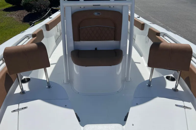 Slide: The Image of 2026 Sea Hunt Ultra 229 boat interior with brown seating and white deck. - 10