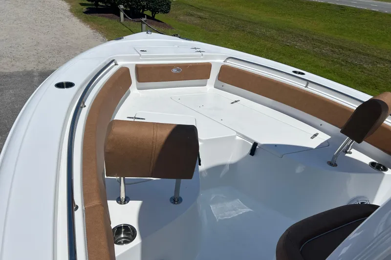 Slide: The Image of 2026 Sea Hunt Ultra 229 boat interior with brown seating and white deck. - 11