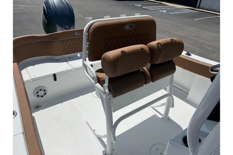 Slide: The Image of 2026 Sea Hunt Ultra 229 boat interior with brown cushioned seating and white deck. - 18