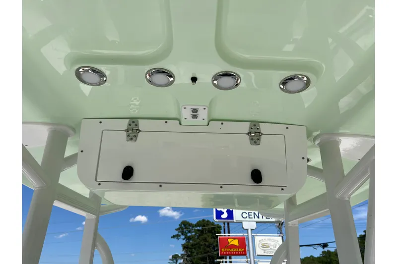 Slide: The Image of 2026 Sea Hunt Ultra 229 boat console with storage compartment and overhead lights. - 22