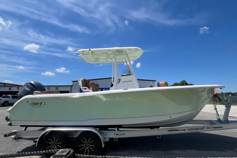 Slide: The Image of 2026 Sea Hunt Ultra 229 boat on trailer under clear blue sky. - 4