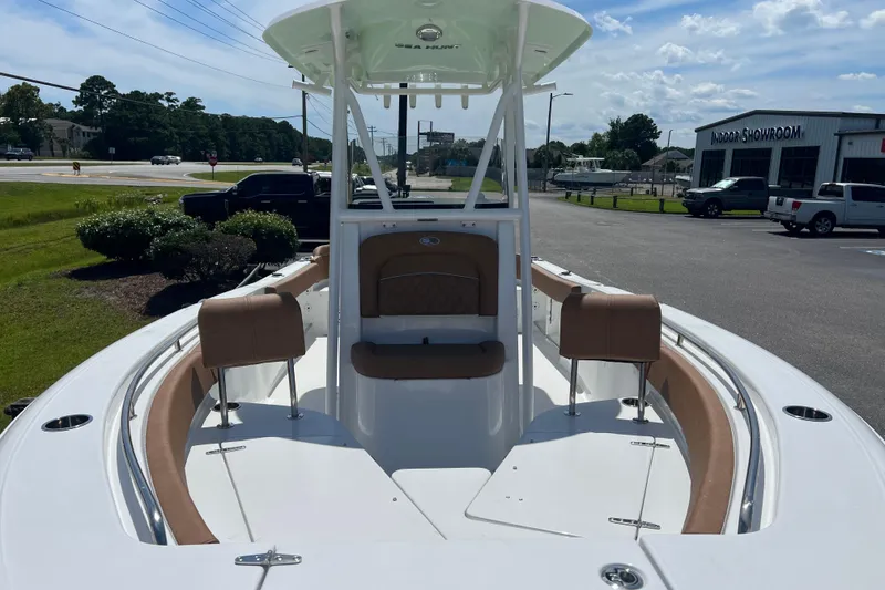 Slide: The Image of 2026 Sea Hunt Ultra 229 boat with spacious seating, parked near a showroom under a clear sky. - 9