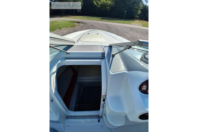 Slide: The Image of 2007 Baja 245 boat interior view with open cabin hatch, parked outdoors. - 20