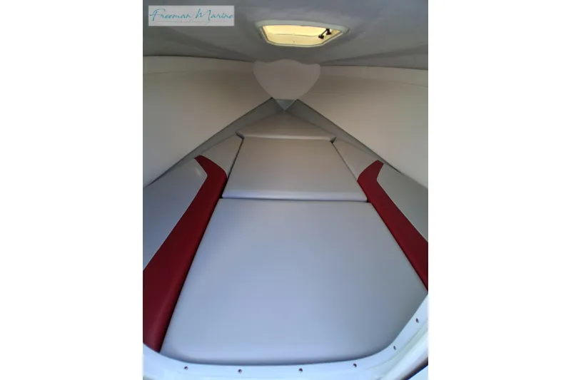 Slide: The Image of Interior cabin of a 2007 Baja 245 boat with red and gray seating. - 22