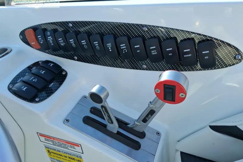 Slide: The Image of Control panel of a 2007 Baja 245 boat with switches and throttle levers. - 24