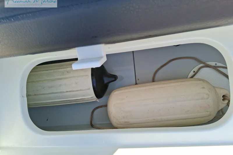 Slide: The Image of Storage compartment in a 2007 Baja 245 boat with two boat fenders. - 28