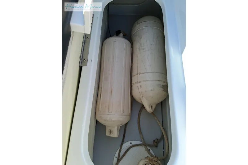 Slide: The Image of Storage compartment with two boat fenders in a 2007 Baja 245. - 36