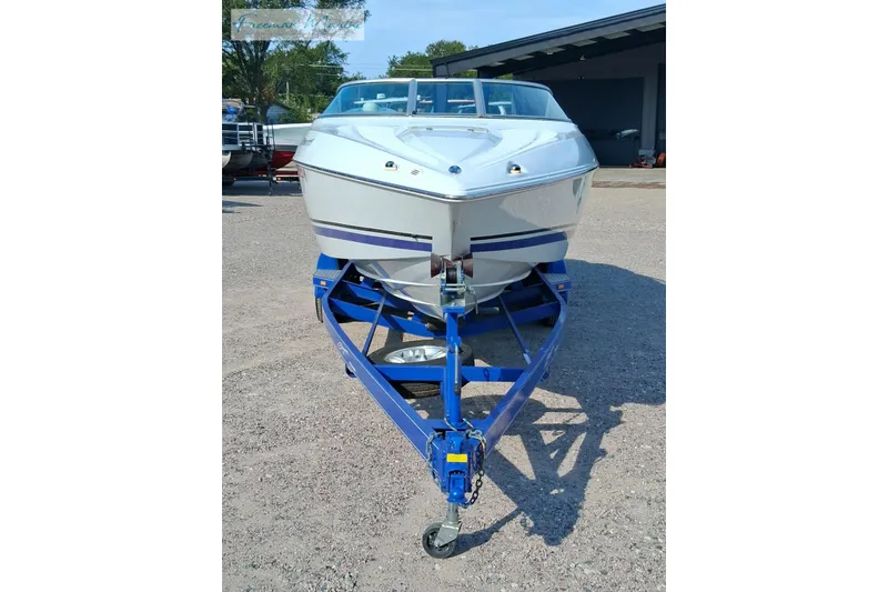 Slide: The Image of 2007 Baja 245 boat on a blue trailer, parked outdoors. - 4