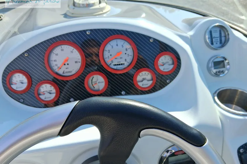 Slide: The Image of Dashboard of a 2007 Baja 245 boat with gauges and steering wheel. - 7