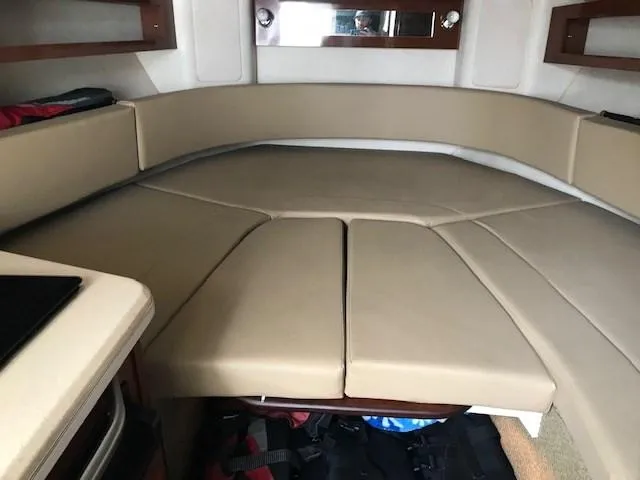 Slide: The Image of 2012 Sea Ray 280 Sundancer cabin interior with beige seating and storage. - 22