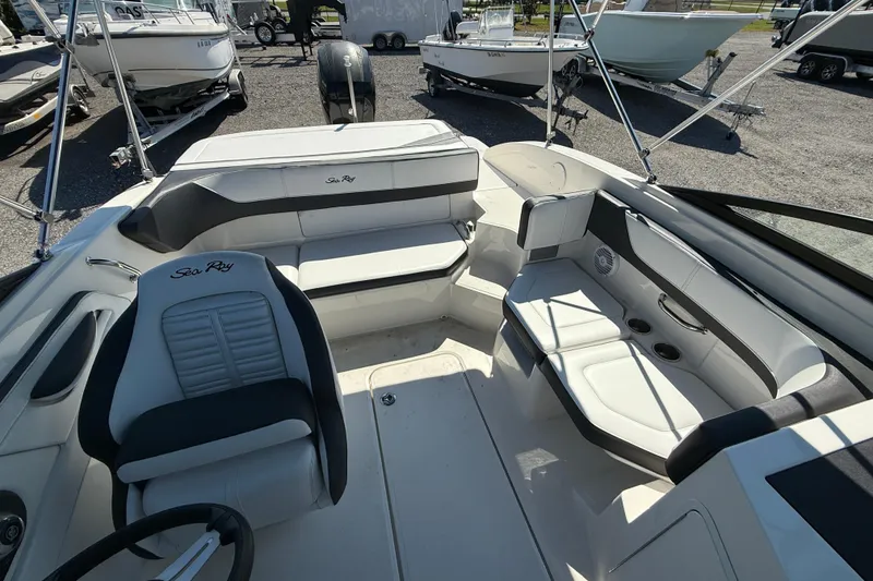 Slide: The Image of 2017 Sea Ray SPX 190 Outboard interior with seating and steering wheel, parked among other boats. - 4