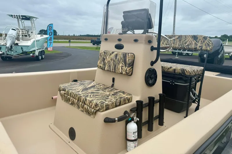 Slide: The Image of 2025 Carolina Skiff E18 JVX CC boat interior with camouflage seating, steering console, and equipment. - 10