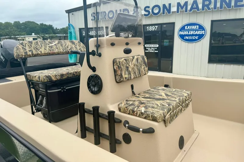 Slide: The Image of 2025 Carolina Skiff E18 JVX CC boat with camo seating, displayed at a marine store. - 11