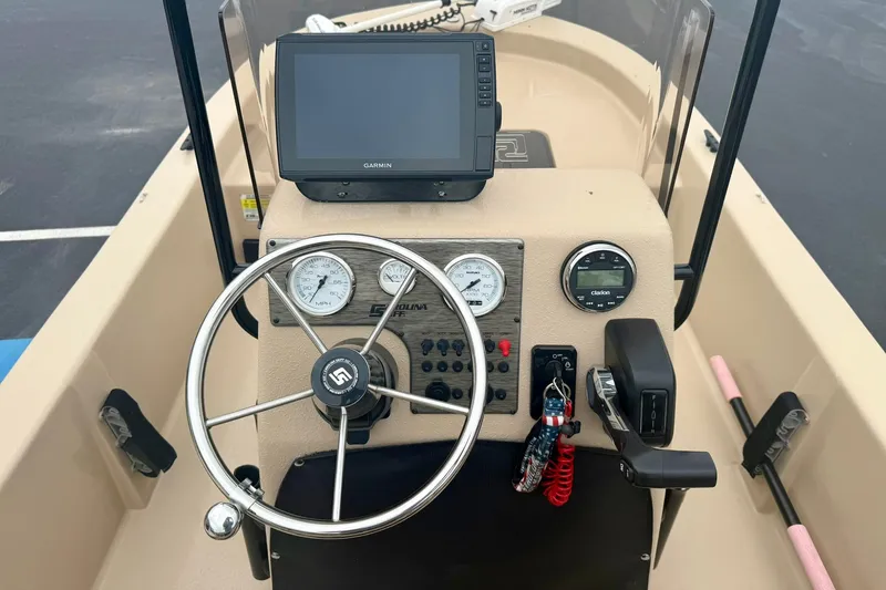 Slide: The Image of 2025 Carolina Skiff E18 JVX CC boat dashboard with Garmin display and steering wheel. - 3