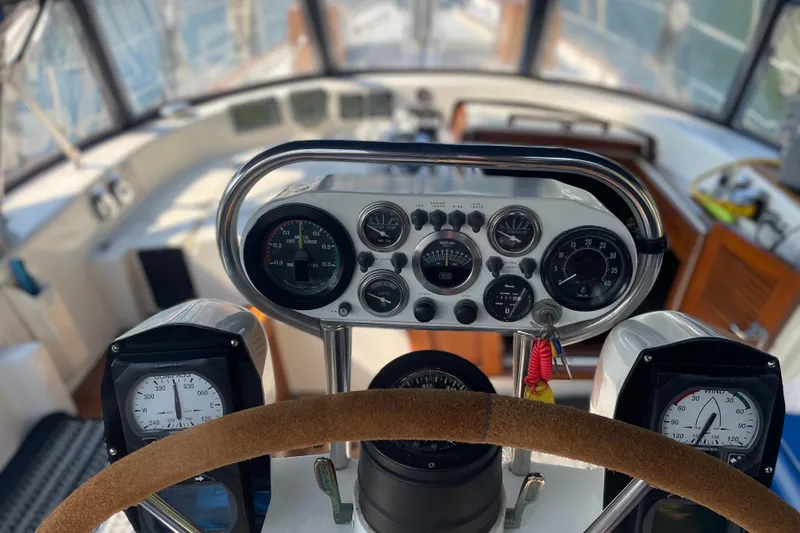 Slide: The Image of Cockpit view of a 1981 Mariner 48 yacht, featuring steering wheel and instrument panel. - 11