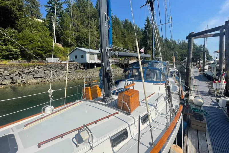 Slide: The Image of 1981 Mariner 48 sailboat docked in a scenic marina with lush greenery. - 2
