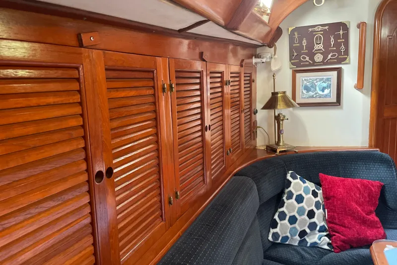 Slide: The Image of Interior of 1981 Mariner 48 yacht with wooden cabinets and cozy seating area. - 23