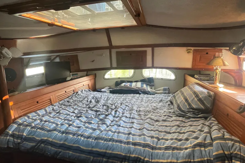 Slide: The Image of Cozy cabin interior of 1981 Mariner 48 yacht with striped bedding and wooden accents. - 27