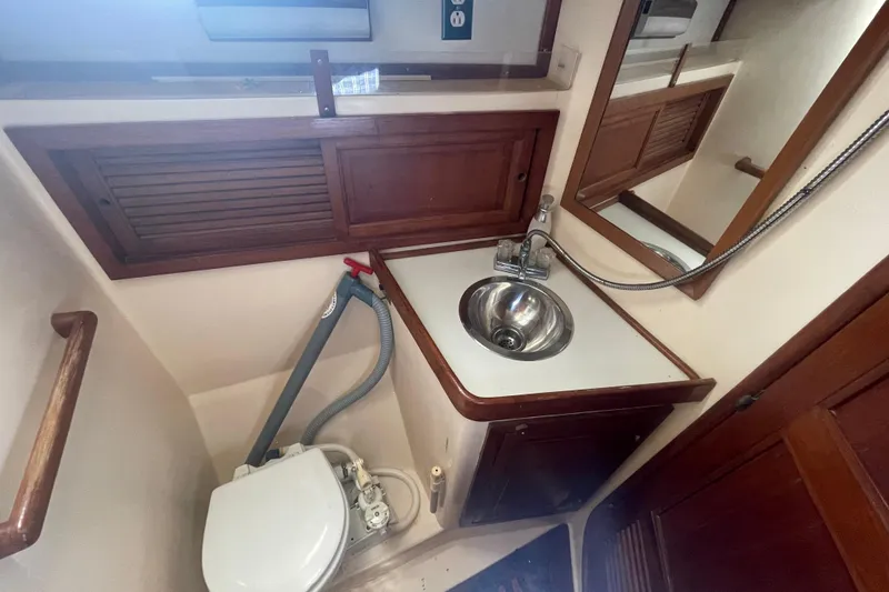 Slide: The Image of 1981 Mariner 48 yacht bathroom with sink, mirror, and toilet. - 32