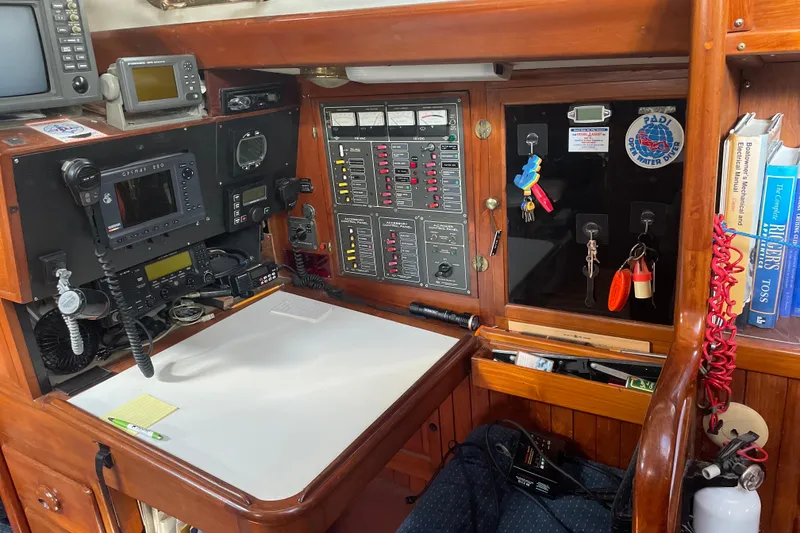 Slide: The Image of 1981 Mariner 48 yacht navigation station with control panels, radios, and nautical books. - 34