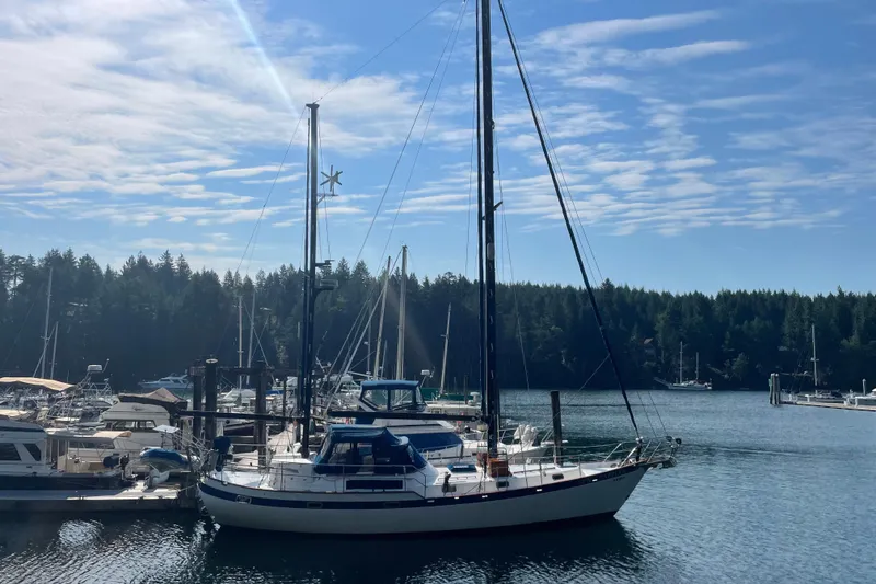 Slide: The Image of Sailboat Mariner 48, 1981 model, docked in a serene marina under a blue sky. - 36