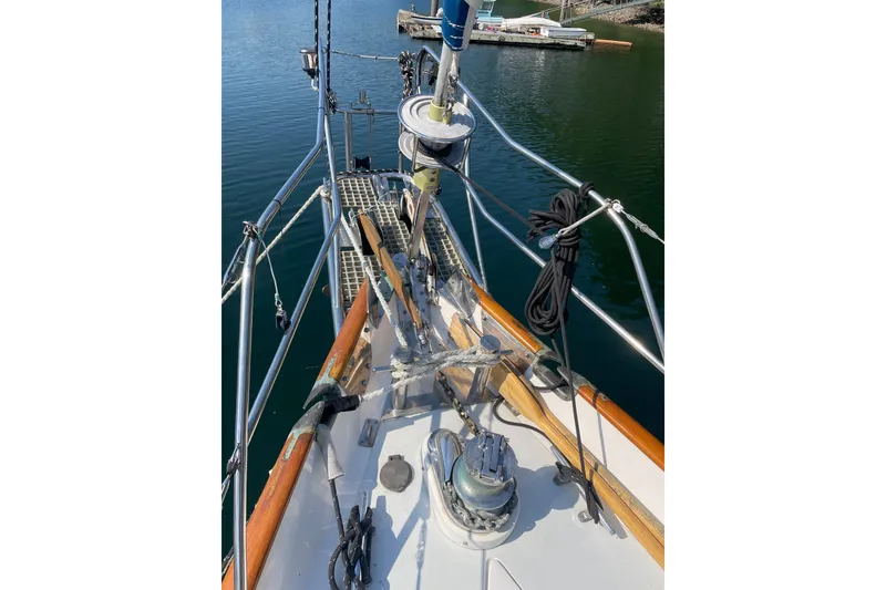 Slide: The Image of 1981 Mariner 48 sailboat deck with rigging and winch, docked on calm water. - 38