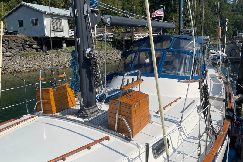Slide: The Image of 1981 Mariner 48 sailboat docked, featuring wooden accents and American flag. - 39