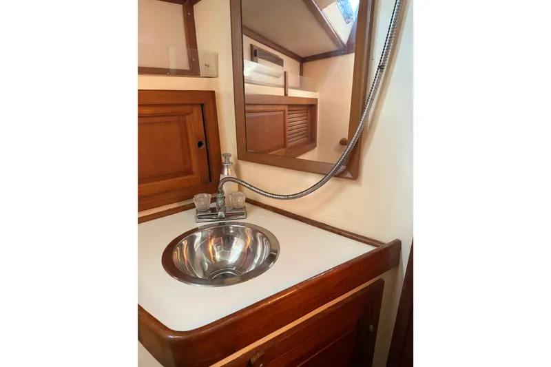 Slide: The Image of 1981 Mariner 48 yacht bathroom with wooden cabinetry and stainless steel sink. - 43