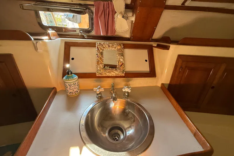 Slide: The Image of 1981 Mariner 48 yacht bathroom with sink, mirror, and decorative elements. - 44