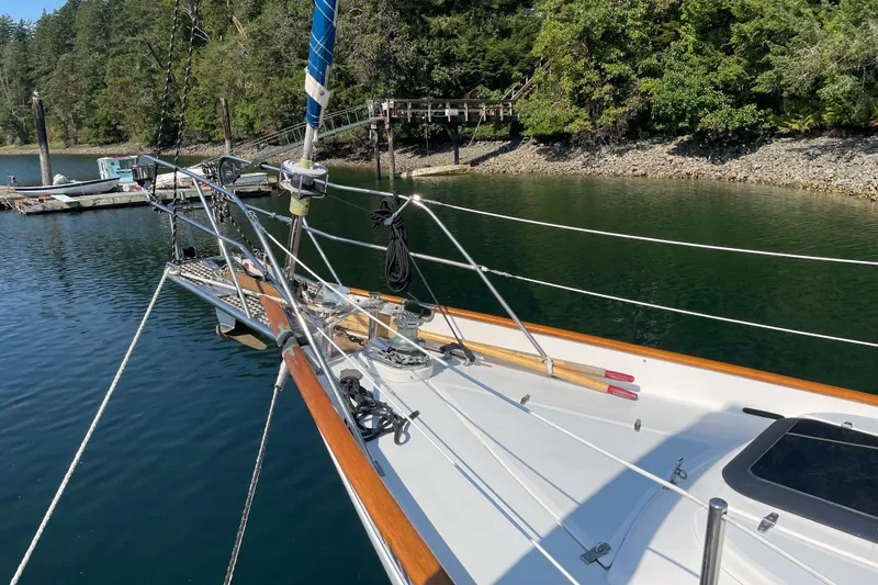 Slide: The Image of 1981 Mariner 48 sailboat docked in a serene, wooded marina setting. - 5