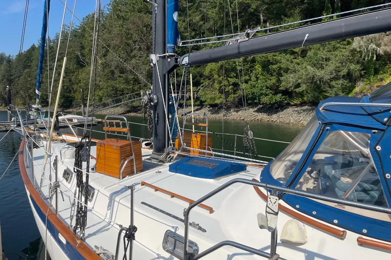 Slide: The Image of 1981 Mariner 48 sailboat docked in a serene, forested marina setting. - 7