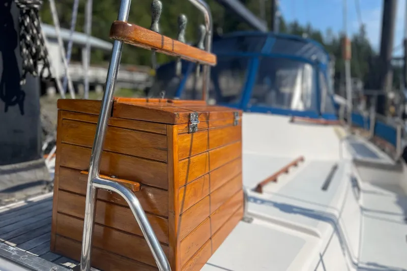 Slide: The Image of Wooden box on 1981 Mariner 48 yacht deck, with metal railing and blurred background. - 9