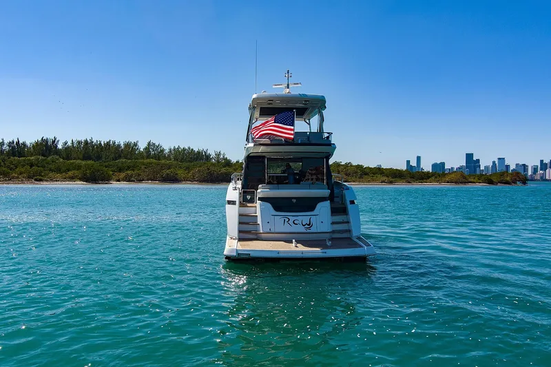 Slide: The Image of 2021 Fairline Squadron 68 yacht on water, American flag, city skyline in background. - 4