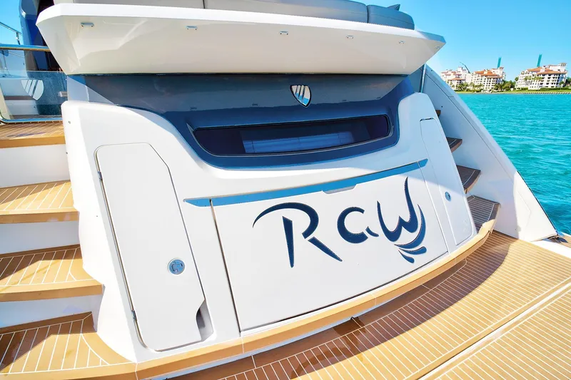 Slide: The Image of 2021 Fairline Squadron 68 yacht stern with custom lettering, docked by turquoise water. - 5