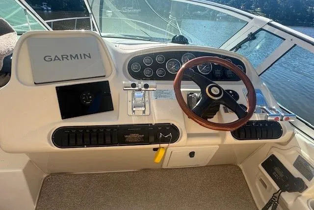 Slide: The Image of 2001 Cruisers Yachts 3672 Express helm with Garmin navigation, steering wheel, and control panel. - 14