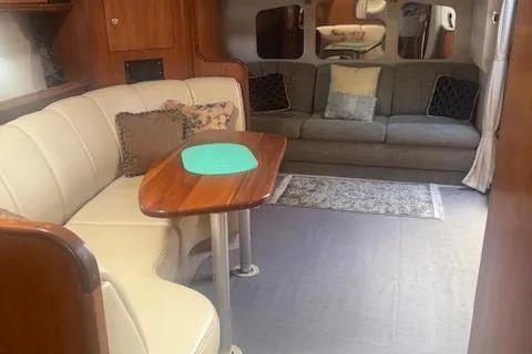 Slide: The Image of Interior of 2001 Cruisers Yachts 3672 Express with cozy seating and wooden table. - 18