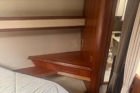 Slide: The Image of 2001 Cruisers Yachts 3672 Express cabin interior with wooden shelves and bed. - 21