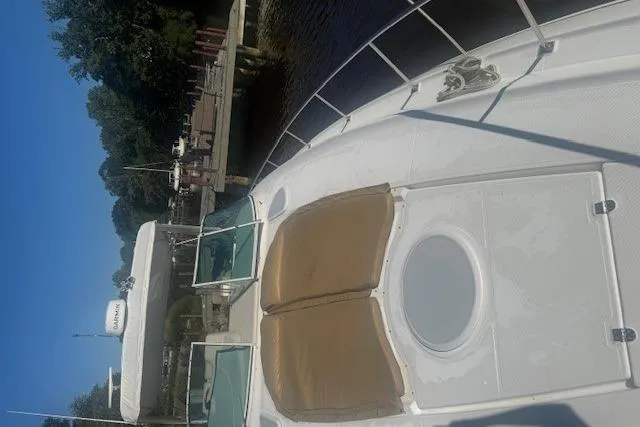 Slide: The Image of 2001 Cruisers Yachts 3672 Express docked, featuring spacious deck and sunbathing area. - 34