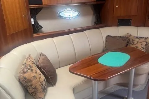 Slide: The Image of 2001 Cruisers Yachts 3672 Express interior with beige seating and wooden table. - 17