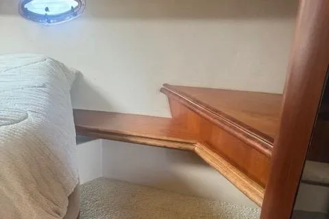 Slide: The Image of Interior of 2001 Cruisers Yachts 3672 Express, featuring wooden steps and a cozy cabin space. - 20