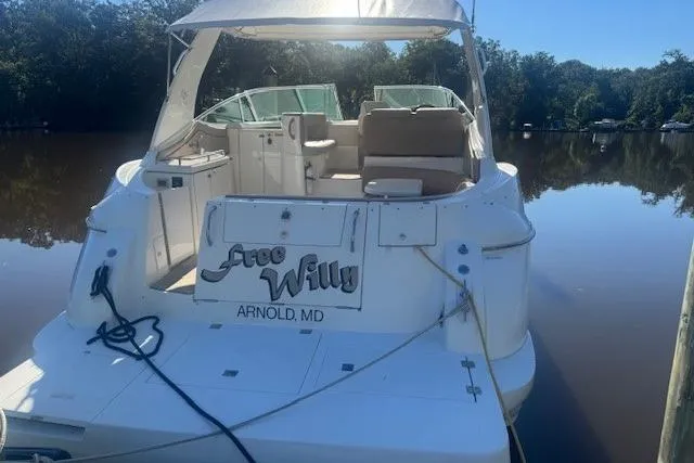 Slide: The Image of 2001 Cruisers Yachts 3672 Express docked on calm water, rear view. - 3