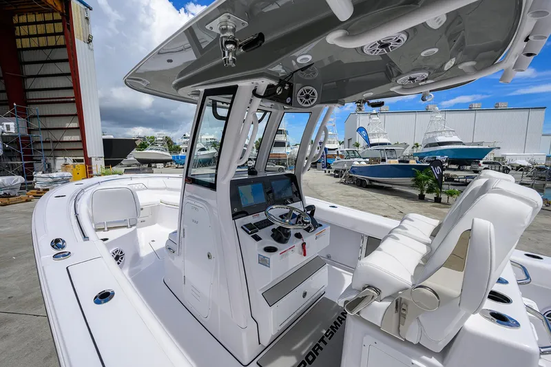 Slide: The Image of 2026 Sportsman Open 262 Center Console boat with modern helm and seating in a marina. - 10