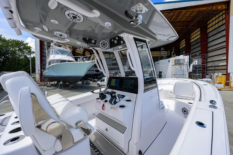 Slide: The Image of 2026 Sportsman Open 262 Center Console boat interior at a marina with other boats. - 12