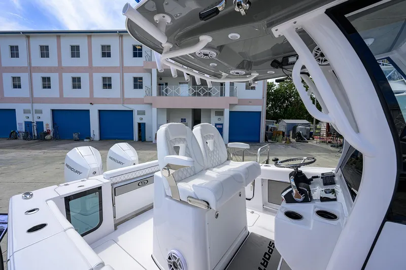 Slide: The Image of 2026 Sportsman Open 262 Center Console boat with dual Mercury engines, docked near a building. - 13