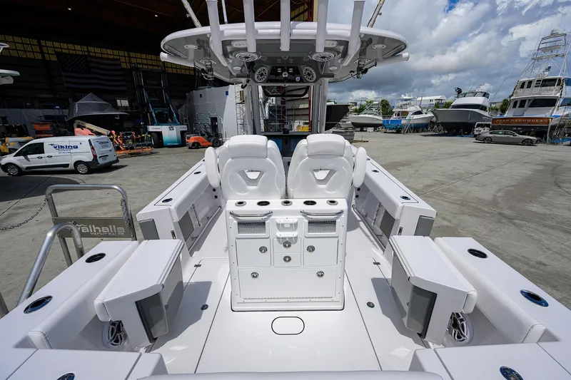 Slide: The Image of 2026 Sportsman Open 262 Center Console boat interior at a marina, showcasing seating and storage. - 14