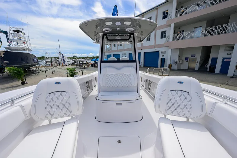 Slide: The Image of 2026 Sportsman Open 262 Center Console boat with sleek seating and modern design at a marina. - 5
