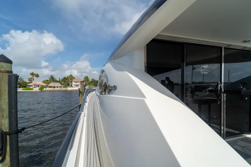 Slide: The Image of 2009 Lazzara LSX 75 yacht docked by waterfront homes under blue sky. - 14